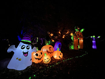 Fantôme souriant et citrouilles illuminées dans le jardin décoré des Nuits des Lumières Halloween en Val de Loire.